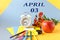 Calendar for April 3: name of the month April in Russian, numbers 03, school supplies, red apple, flowers, alarm clock on a blue