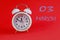 Calendar en March 3: white alarm clock on a crimson background close-up, numbers 03, the name of the month March in English