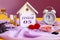 Calendar for January 5: decorative house with the name of the month in English, number 05, various cosmetics, white alarm clock,