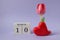 Calendar for March 10: cubes with the number 10, the name of the month March in English, a scarlet tulip in a heart vase on a