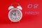 Calendar for March 8: a white alarm clock on a crimson background close-up, the numbers 08, the name of the month March in