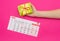 Calendar with marked days of menstruation in a girl, female hand with a stack of sanitary pads, pink background, period, pms