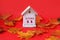 Calendar for October 11 : decorative house with the name of the month in English, number 11, autumn maple leaves on a red