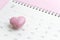 Calendar with pink heart shape on 14 February on pink background