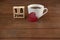 Calender date by coffee cup with heart shape on wooden table