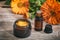 Calendula essential oil and ointment on a wooden table, fresh blooming calendula background,