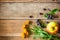 Calendula flowers, aronia berries (black chokeberry) and apple on wooden background in rustic style