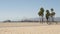 California beach aesthetic, people ride cycles on a bicycle path. Blurred, defocused background. Amusement park on pier