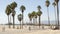 California beach aesthetic, people ride cycles on a bicycle path. Blurred, defocused background. Amusement park on pier