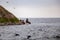 A California Sea Lion sits on the water`s edge of a rock