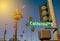 A California Street Sign on a Traffic Pole with the Red Sun Shining on Palm Trees