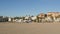 California summertime beach aesthetic, sunny blue sky, sand and many different beachfront weekend houses. Seafront