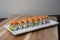 California sushi roll topped wit salmon. Japanese traditional dishes combine with American ingredients