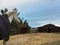 California winter - horse bundled in blanket looking at barn with storm clouds looming overhead