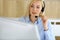 Call center. Blonde business woman sitting in headset at customer service office. Concept of telesales business or home