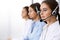 Call center. Group of operators at work. Focus at beautiful business woman in headset