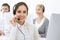 Call center. Group of operators at work. Focus on beautiful woman receptionist in headset at customer service white