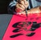 Calligrapher writing words on paper prosperous in Chinese word