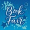 Calligraphy lettering of Book Fair in white with blue outline on blue background decorated with stars and watercolor