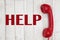 Calling for help message with retro red phone handset on weathered whitewash wood