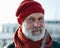 Calm aged man in red knitted hat. White bearde man portrait. Sailor man with grey haired beard