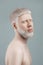 Calm albino bearded guy with closed eyes posing against grey background in studio