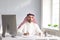 Calm arabian man sits at a table in the office. A