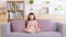 Calm of Asian child cute making yoga meditation with inhale and exhale. Sit on couch for focusing mind and soul. Relaxed with hand