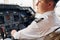 Calm atmosphere. Pilot in formal wear sits in the cockpit and controls airplane