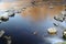 Calm atmospheric picture of large stones lying in a river in the evening, around which the water flows very calmly and which form