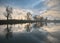 Calm autumn morning landscape with fog and warm sky over pond surrounded by trees with a beautiful reflections in the water