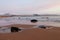 Calm beach at dawn, with snow covered hills