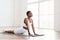 Calm black woman stretching back on mat in cobra pose