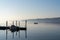 Calm blue lake with moored ship and a small motorboat cruising through the water