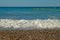 Calm blue mediterranean sea with pebble beach blue sky