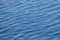 Calm blue water background with small ripples, texture