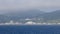 Calm blue water and coastal town under high fog layer on Rebun Island