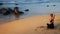 Calm brunette meditates on sandy beach under sunlight