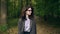 Calm businesswoman in glasses walking in an autumn forest