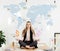 calm businesswoman meditating in lotus position on table in office with dollar sign and cogs in hands and world map