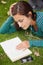 Calm casual student lying on grass reading a book