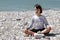 Calm child meditating for inner peace, wellbeing and wisdom, beach