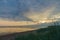 Calm and colourful cloudscape sunrise at sea gulf with tall grass on beach