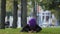 Calm concentrated young islamic muslim woman girl in hijab sitting in park on grass outdoors doing yoga exercises