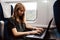 Calm concentrated young woman work in train during travelling. Typing on laptop keyboard. Sit alone in wagon at window