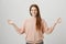 Calm confident ginger girl standing in meditation pose with spreaded hands and zen gesture, smiling broadly and being in