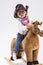 Calm and Confident Little Caucasian Girl in Cowgirl Clothing On Symbolic Horse