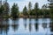 calm countryside lake river with cloud reflections in water and green shores