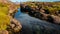 Calm creek flowing through moss coverd rocks towards waterfall volcanic landscape