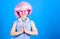 Calm and cute. Cute child clasping hands together. Cute little girl wearing pink wig and fancy glasses with praying